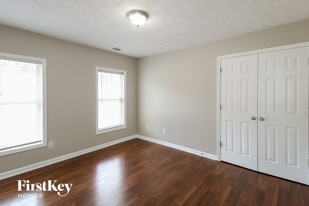 a bedroom with a hard wood floor and two white doors