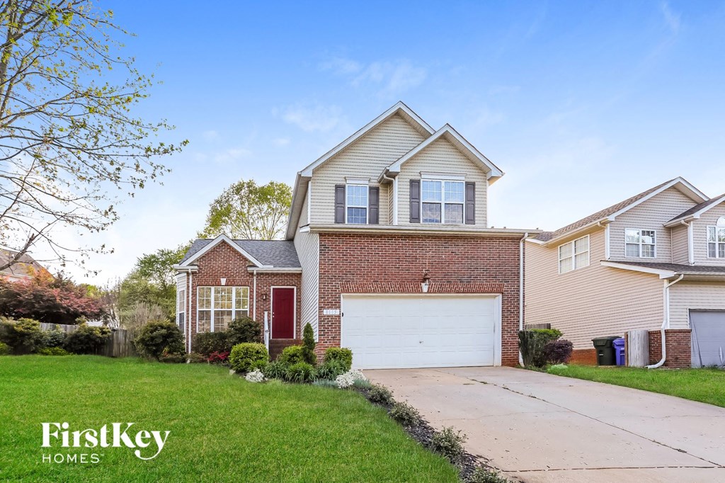 A house with a red door and a garage is shown in the image.