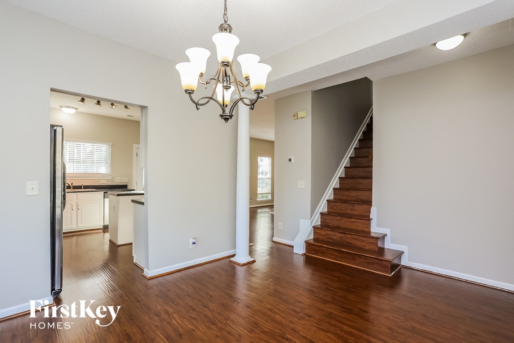 A large, empty room with a staircase leading to the second floor.