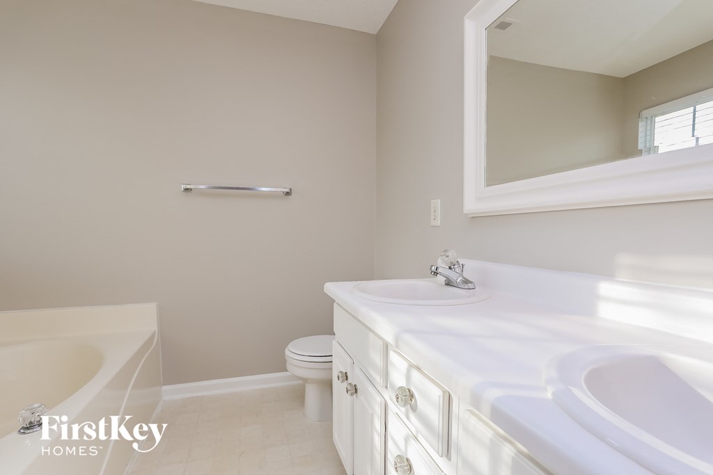 A white bathroom with a tub, toilet, and sink.