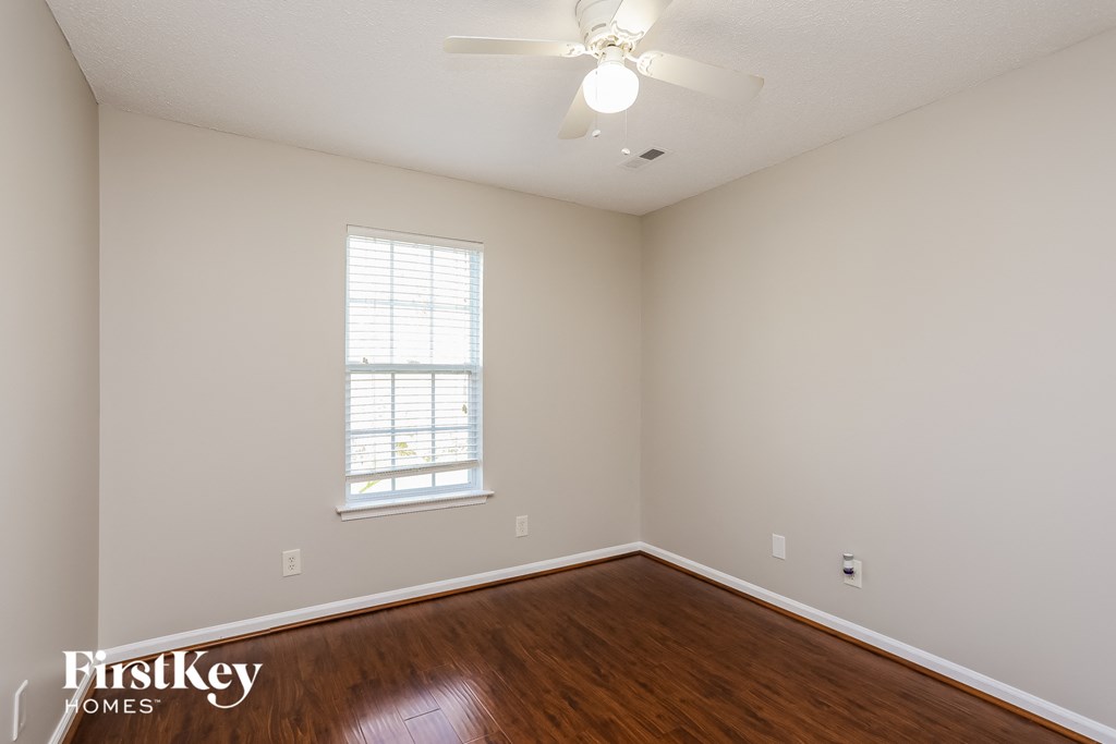 A room with a window and a fan on the ceiling.