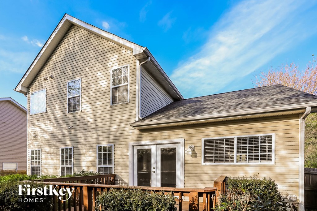 A house with a brown facade and a white door is for sale by FirstKey Homes.