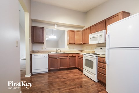 A kitchen with wooden cabinets and white appliances.