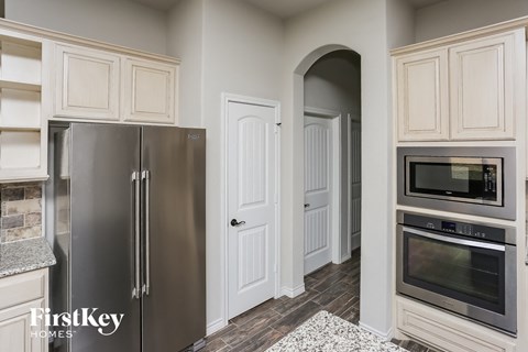 A kitchen with a stainless steel refrigerator and a microwave oven.