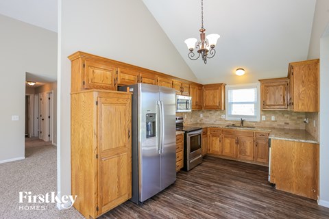 A kitchen with wooden cabinets and a refrigerator.