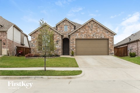 a large brick house with a driveway and a garage door