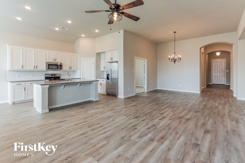 an open kitchen and living room with a ceiling fan