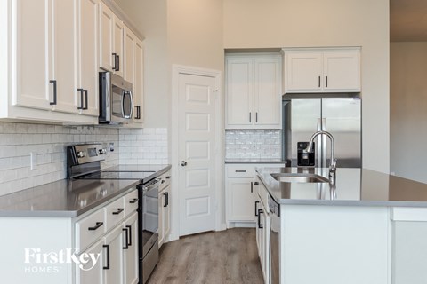 a white kitchen with stainless steel appliances and white cabinets