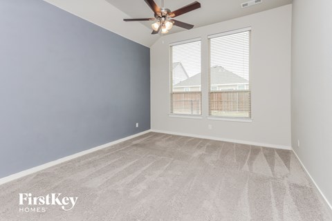 a bedroom with a ceiling fan and a window