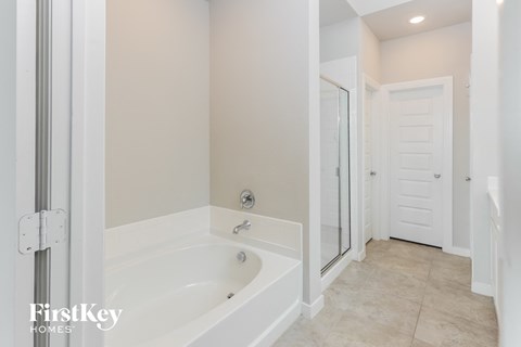 a white bathroom with a large tub and a shower