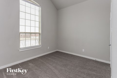 a bedroom with a carpeted floor and a window