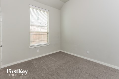 a bedroom with a carpeted floor and a window