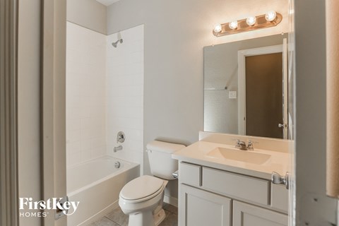 a white bathroom with a sink and toilet and a tub