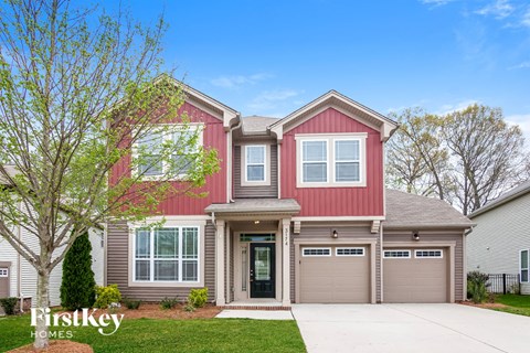 a renovated home with a red exterior and a gray garage door