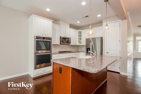 a kitchen with white cabinets and a granite counter top