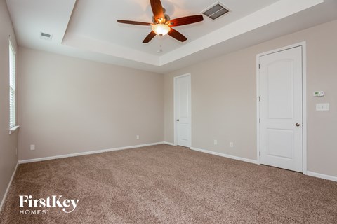 a bedroom with carpet and a ceiling fan