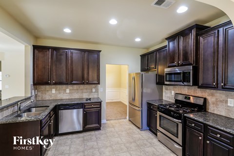 a kitchen with dark wood cabinets and stainless steel appliances