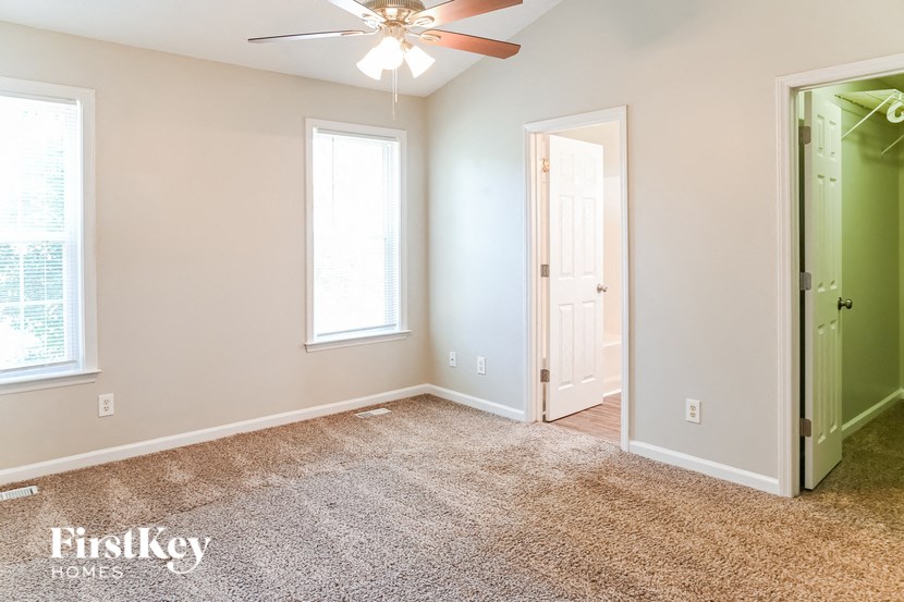 a bedroom with a carpeted floor and a ceiling fan