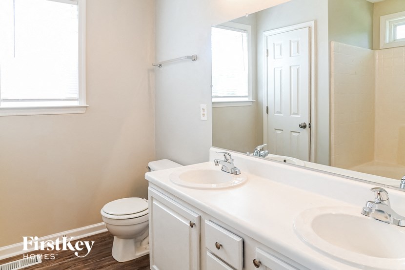 a bathroom with a toilet and a sink and a mirror