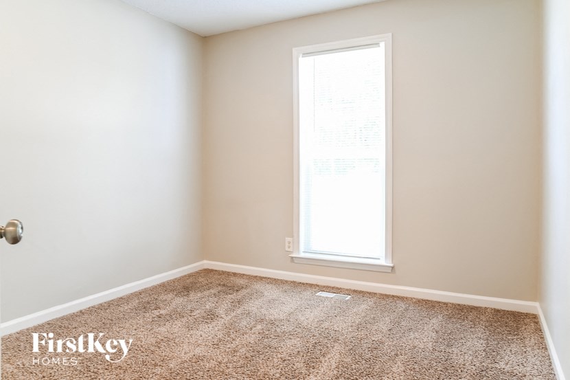 a empty room with a window and a carpet