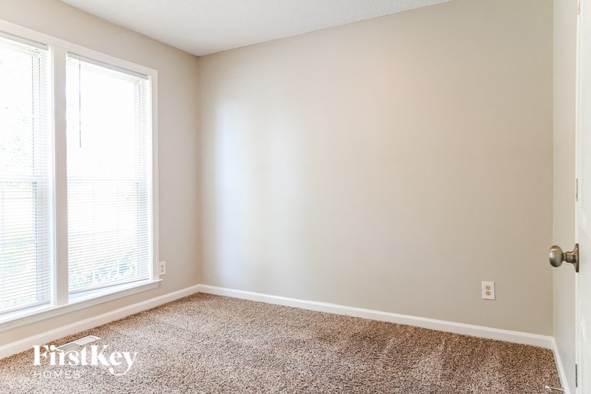 a bedroom with a carpeted floor and two windows
