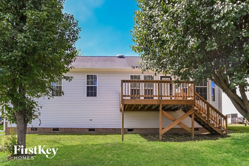 the back of a house with a deck and a tree