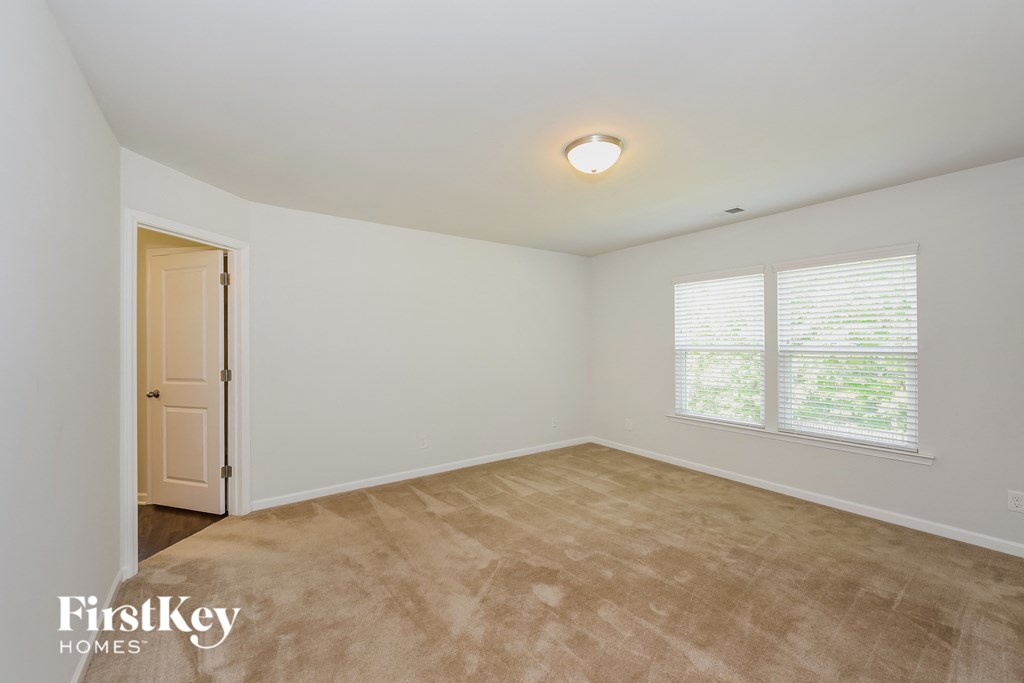 the living room of a home with a carpeted floor and a door and window