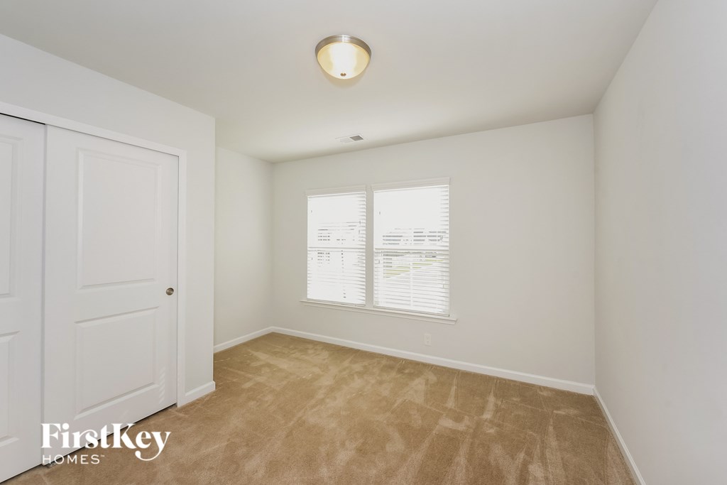 a bedroom with a closet and a window and a door