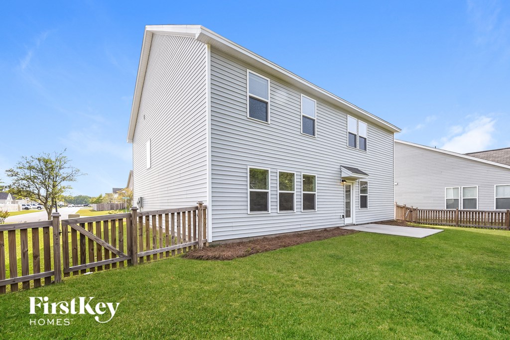 a white house with a yard and a wooden fence