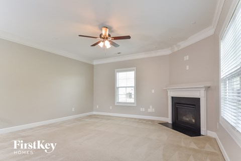 a living room with a fireplace and a ceiling fan