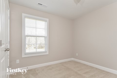 a bedroom with a window and a white door