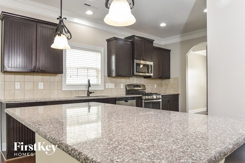 a kitchen with granite counter tops and dark cabinets