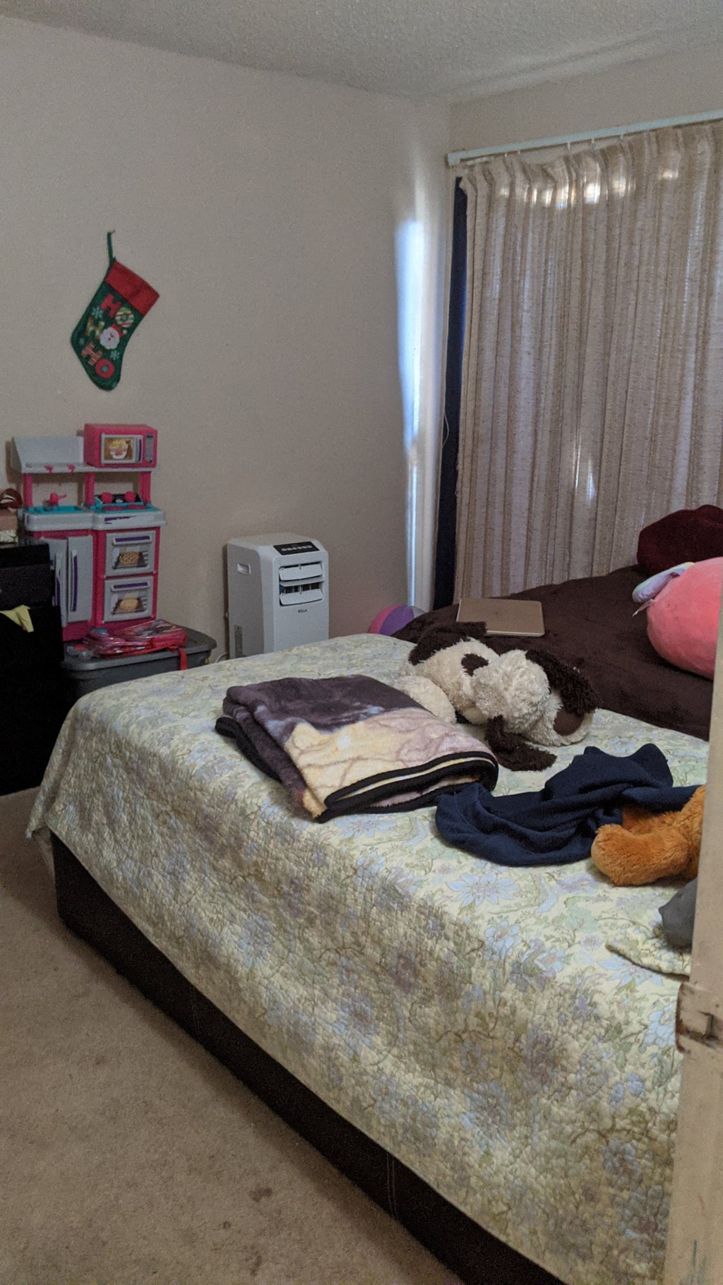 a bed with clothes and a stuffed animal on it