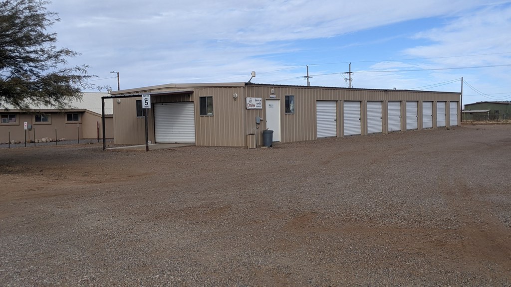 a large building with roll up doors and a parking lot