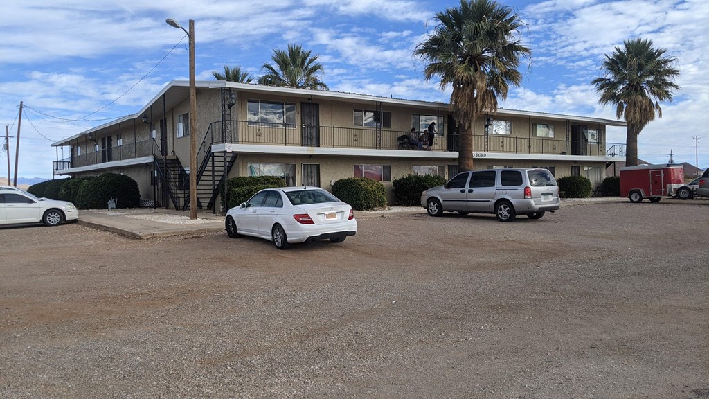 a large motel with cars parked in front of it