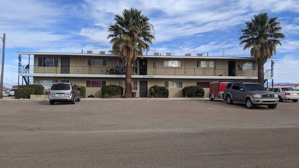 an old motel with cars parked in front of it