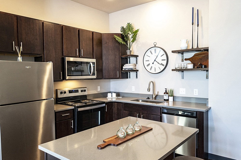 a kitchen with stainless steel appliances and a clock on the wall