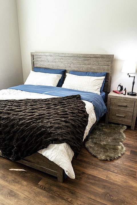 a bedroom with a bed and pillows and a rug