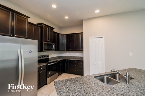 A kitchen with a sink and a refrigerator.