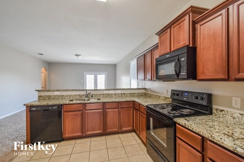 A kitchen with wooden cabinets and granite countertops.