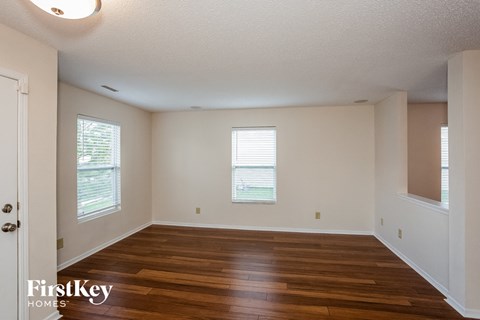 the living room of an empty house with wood floors and white walls
