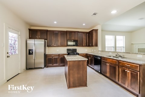 A kitchen with brown cabinets and a refrigerator.