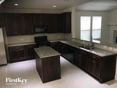 a kitchen with dark wood cabinets and granite counter tops