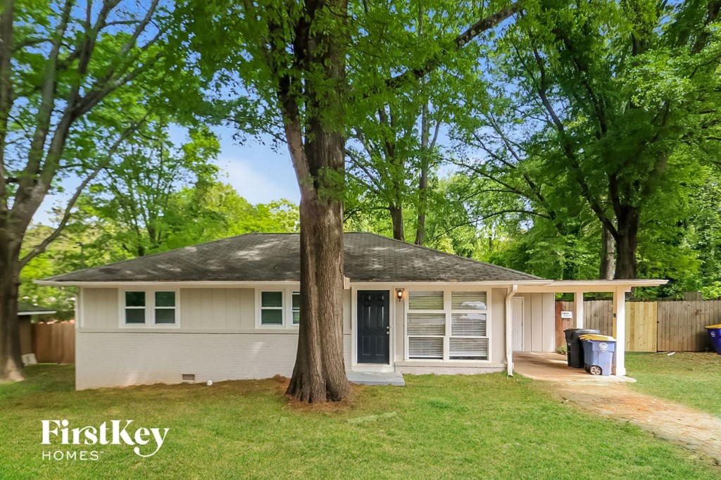 a small white house with a tree in front of it