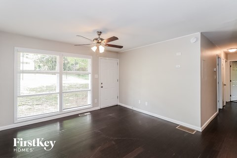 a living room with a ceiling fan and a large window