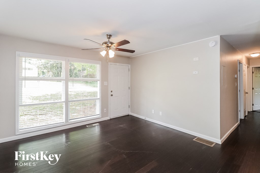 a living room with a ceiling fan and a large window