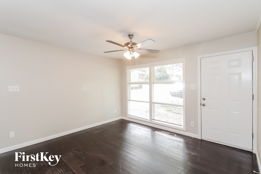 a living room with wood floors and a ceiling fan