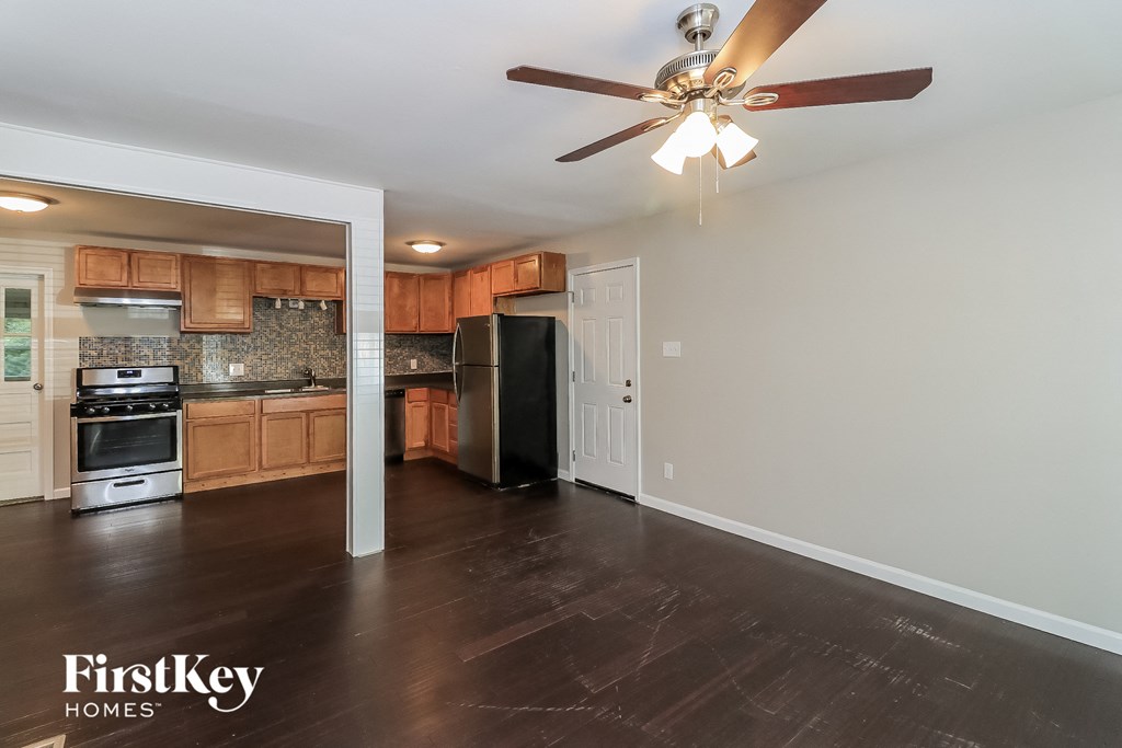 a kitchen with wood floors and a ceiling fan