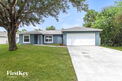 a blue house with a white garage door and a lawn