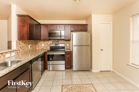 a kitchen with stainless steel appliances and wooden cabinets